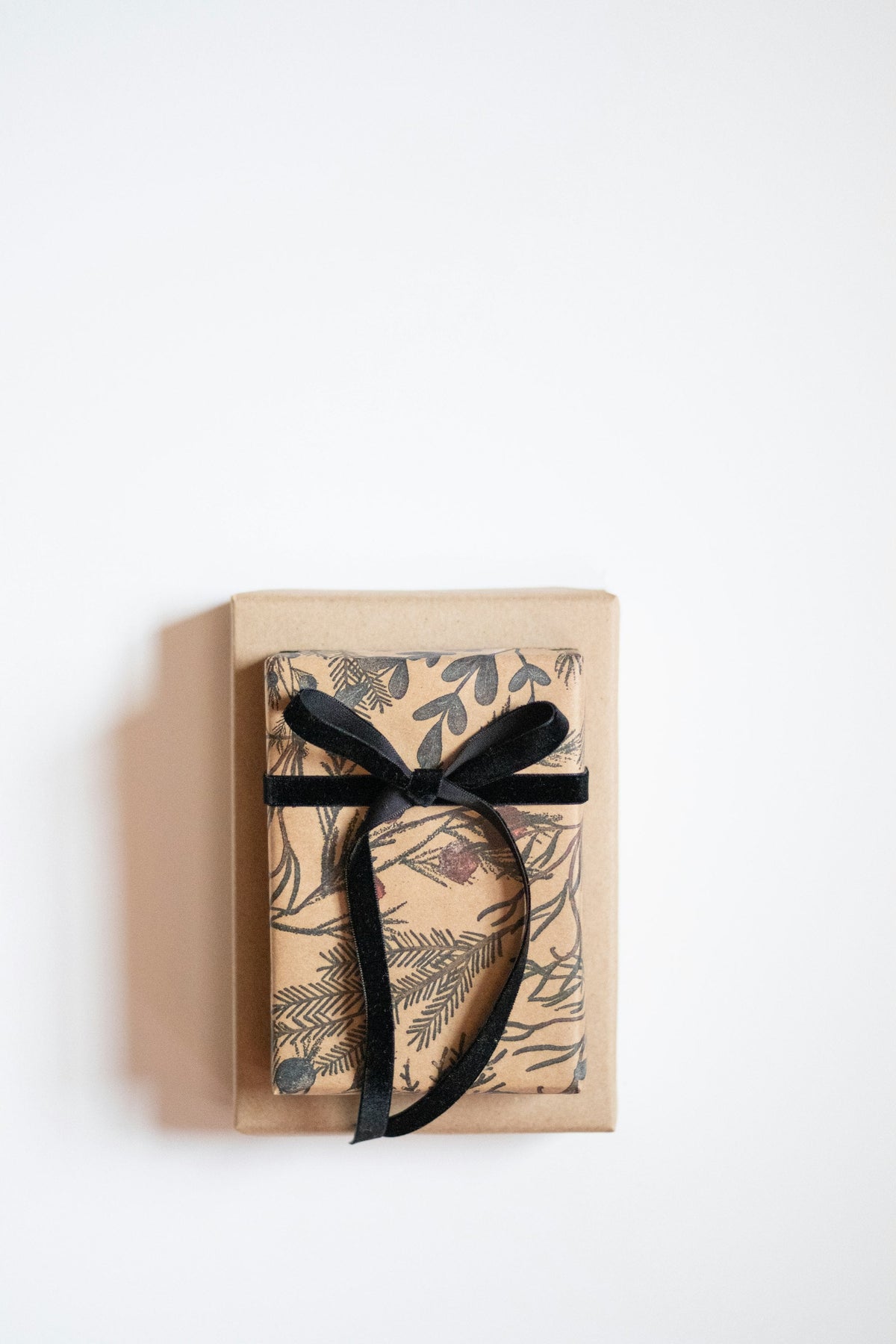 Elegantly wrapped gift box with a black velvet ribbon bow