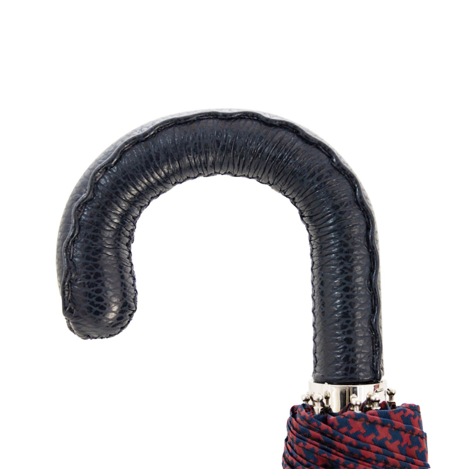 Folding umbrella with Italian handmade leather handle, compact rain gear from Pasotti, open to show waterproof canopy.
