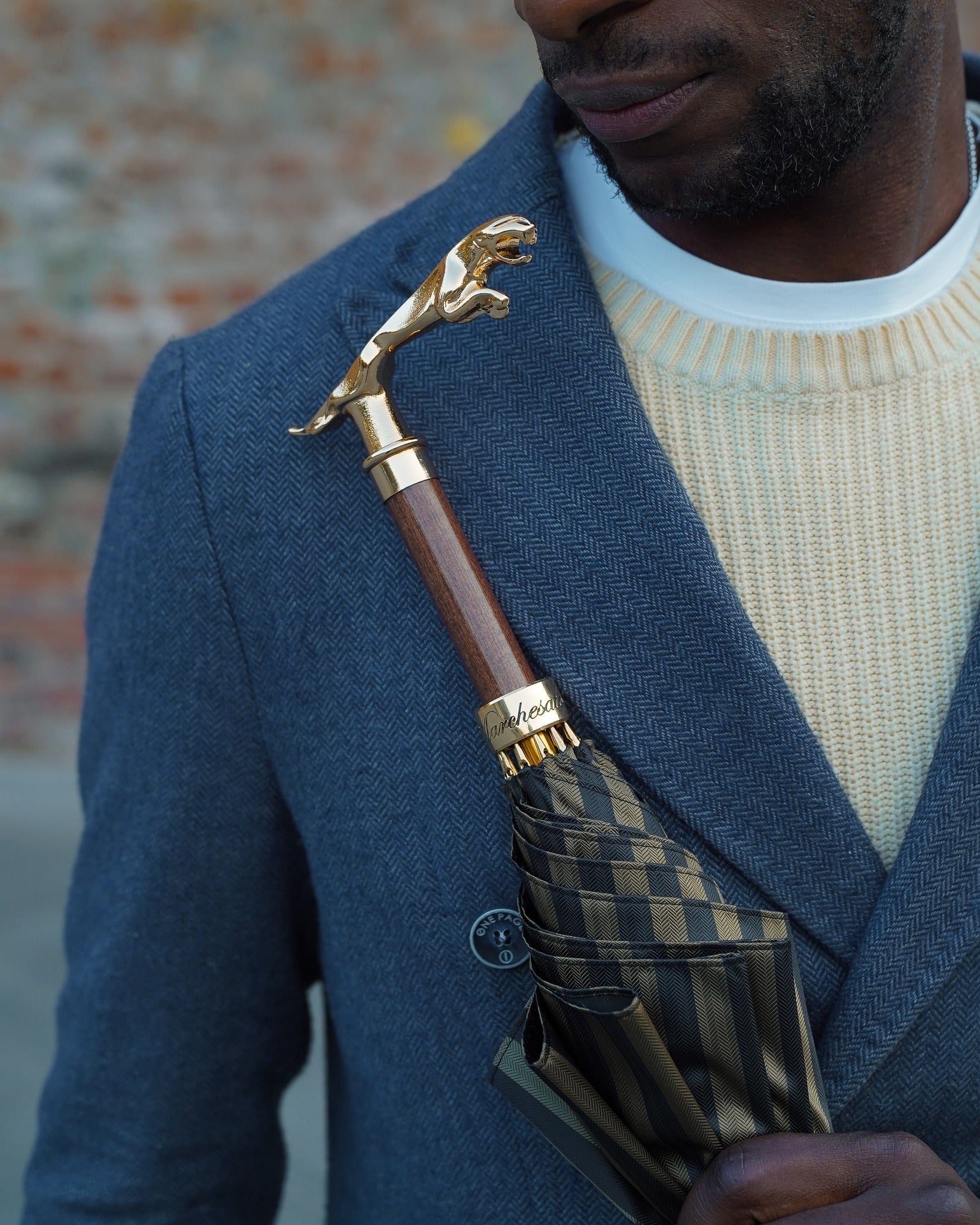 Black pinstripe men's umbrella by Ilmarchesato with 24K gold handle and automatic opening for luxury rain protection.