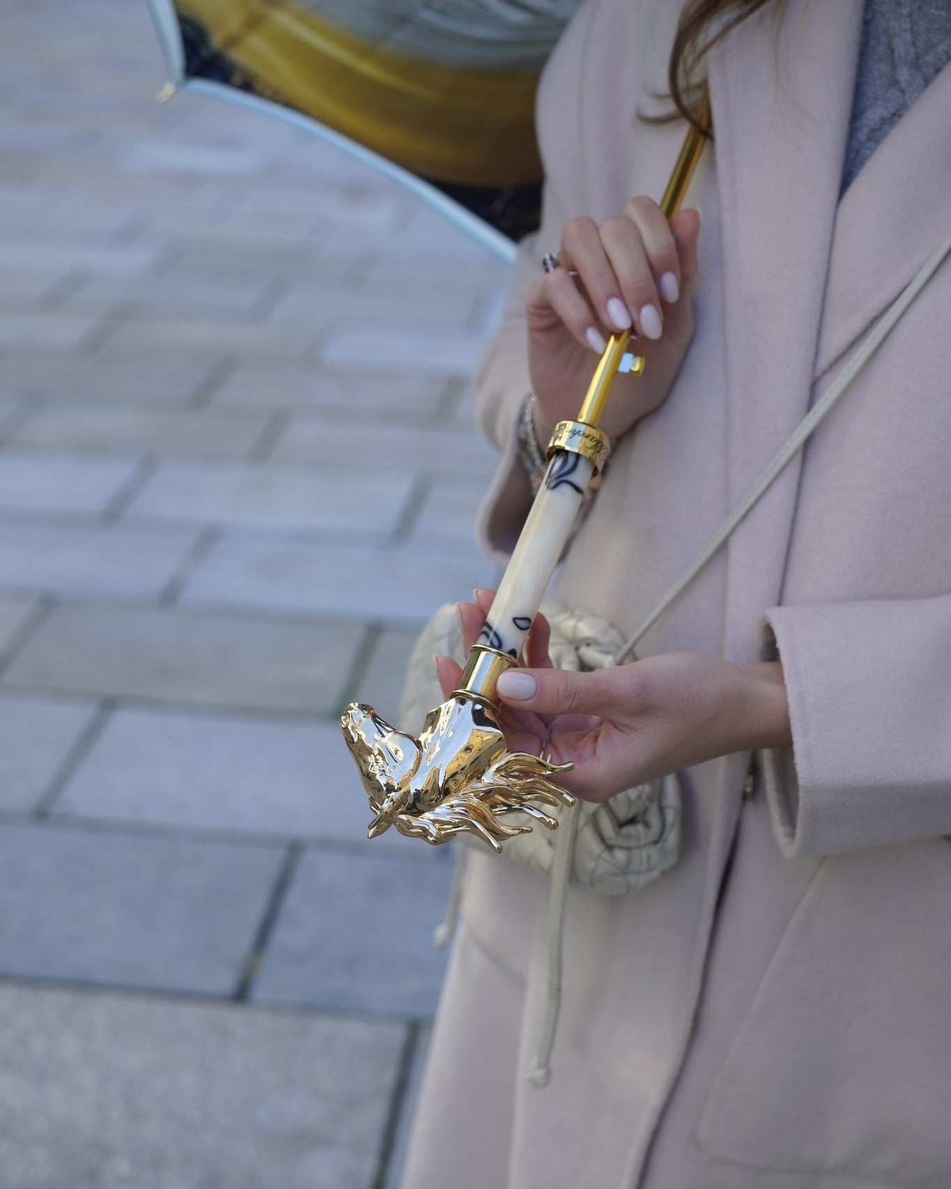 Light blue Ilmarchesato rain umbrella with gold horse handle and silk satin canopy, elegant rain protection in a detailed close-up image.