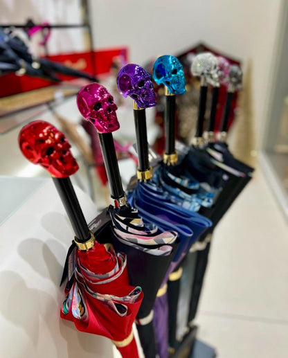 Handmade Italian luxury rain umbrella by Pasotti featuring a red skull design and a resin handle.