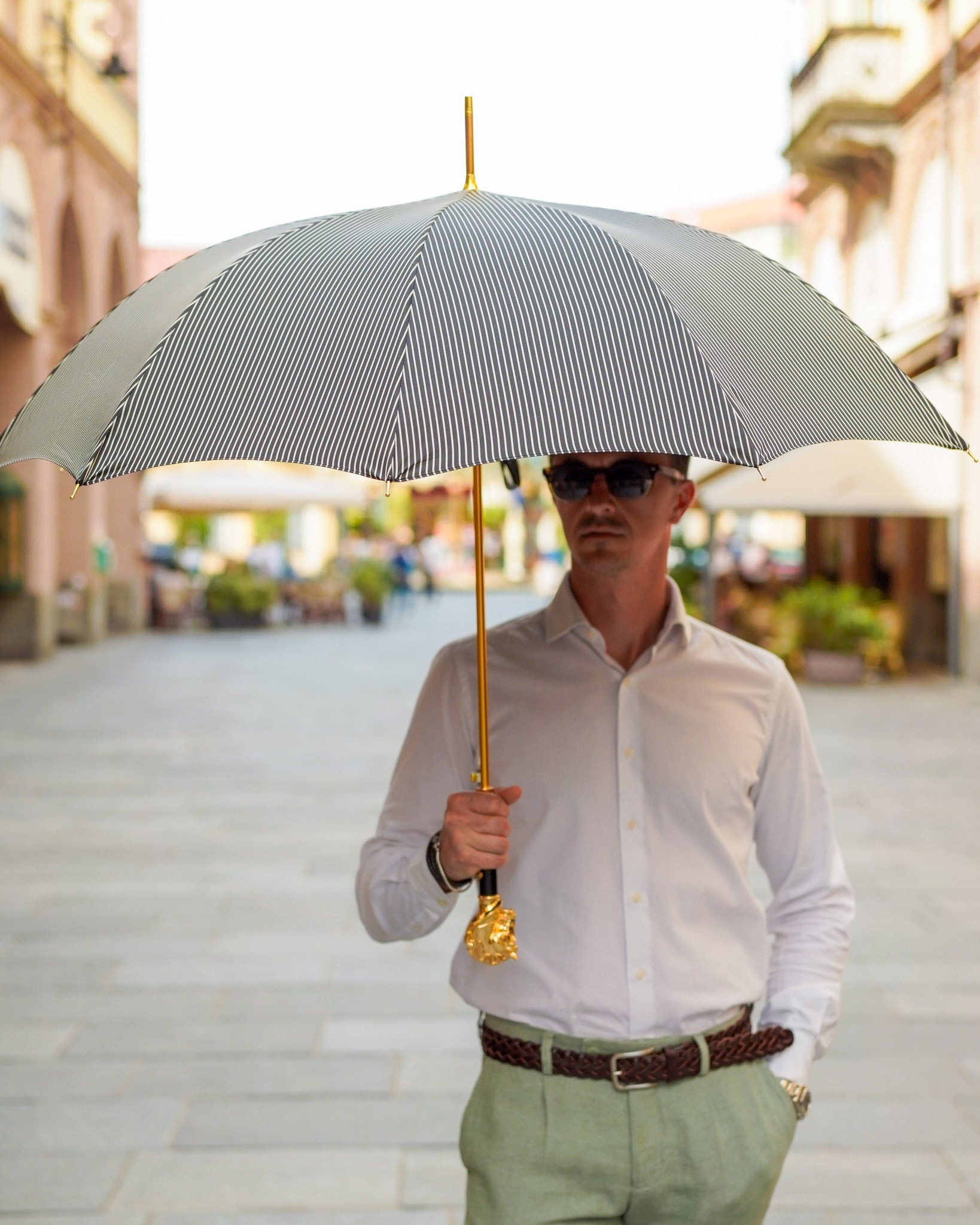 Black striped men's umbrella by Ilmarchesato with a 24K gold horse handle, stylish luxury rain protection for gentlemen.