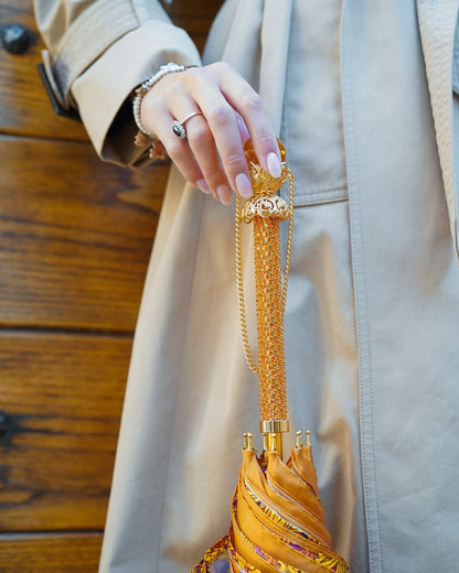 Handmade orange leopard rain umbrella by Ilmarchesato with a luxurious 24K gold handle, stylish waterproof umbrella for rainy days.