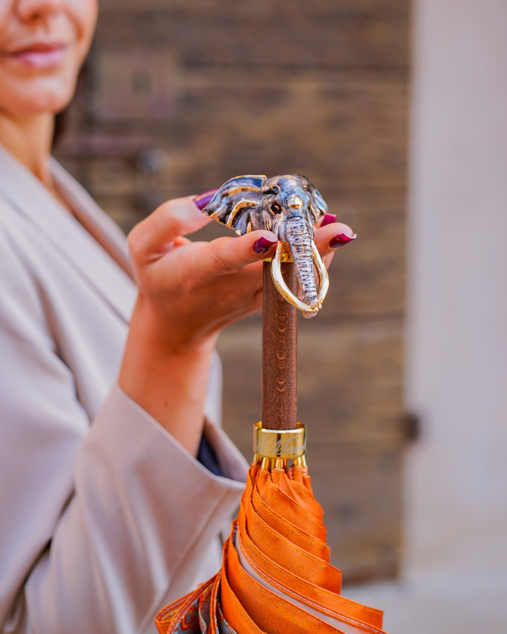 Golden elephant-shaped rain umbrella with satin canopy and 24K gold handle by Ilmarchesato, stylish rain protection accessory.