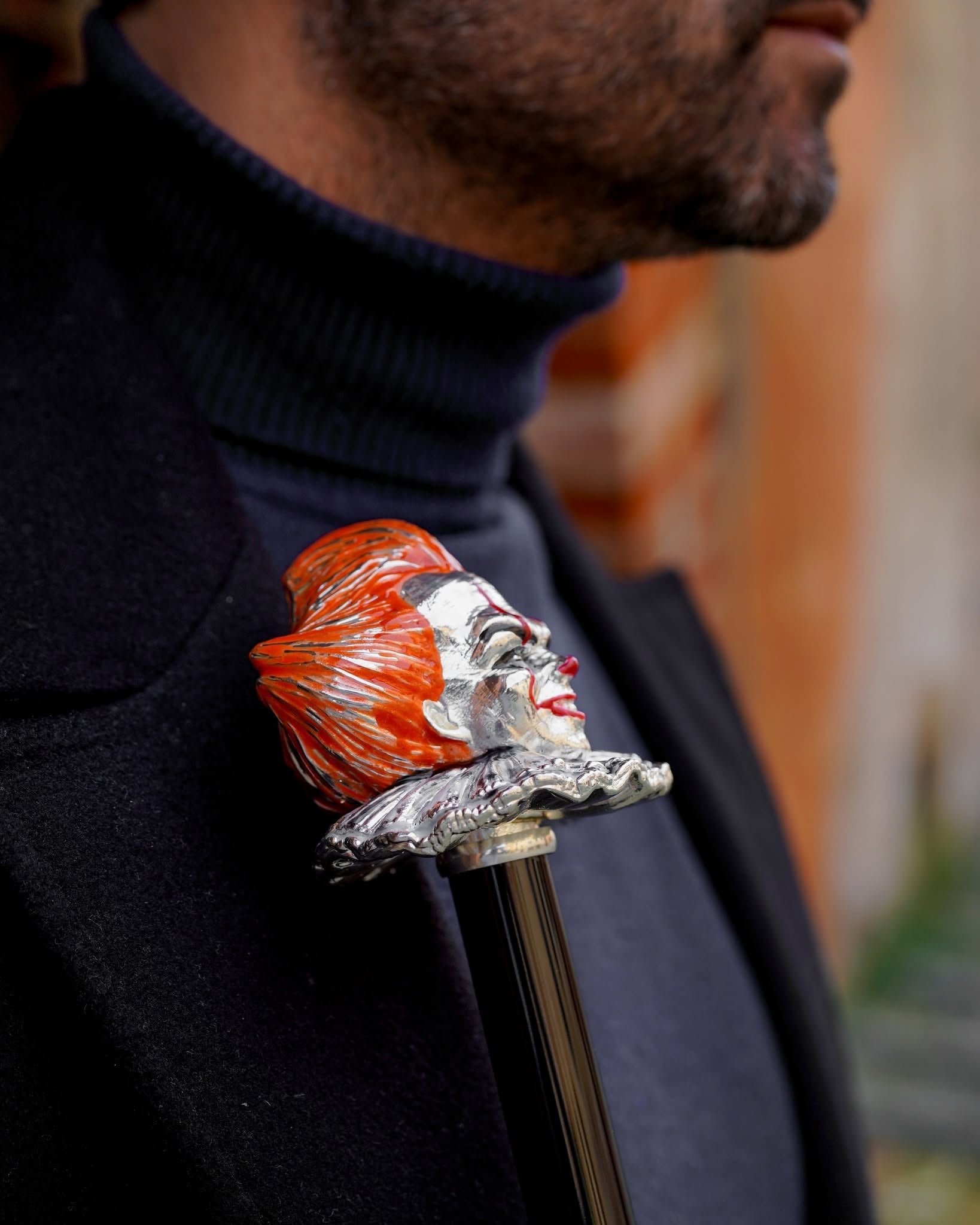 Grey men's umbrella with hand-painted clown handle, showcasing Italian craftsmanship and stylish design.