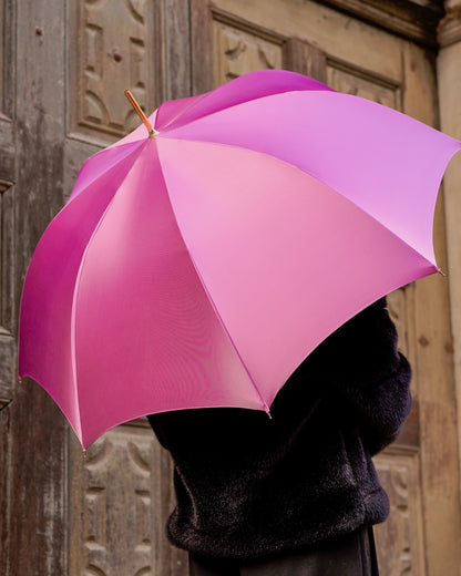 Luxury pink rain umbrella by Ilmarchesato with hand-painted floral handle and satin canopy, wind-resistant design.