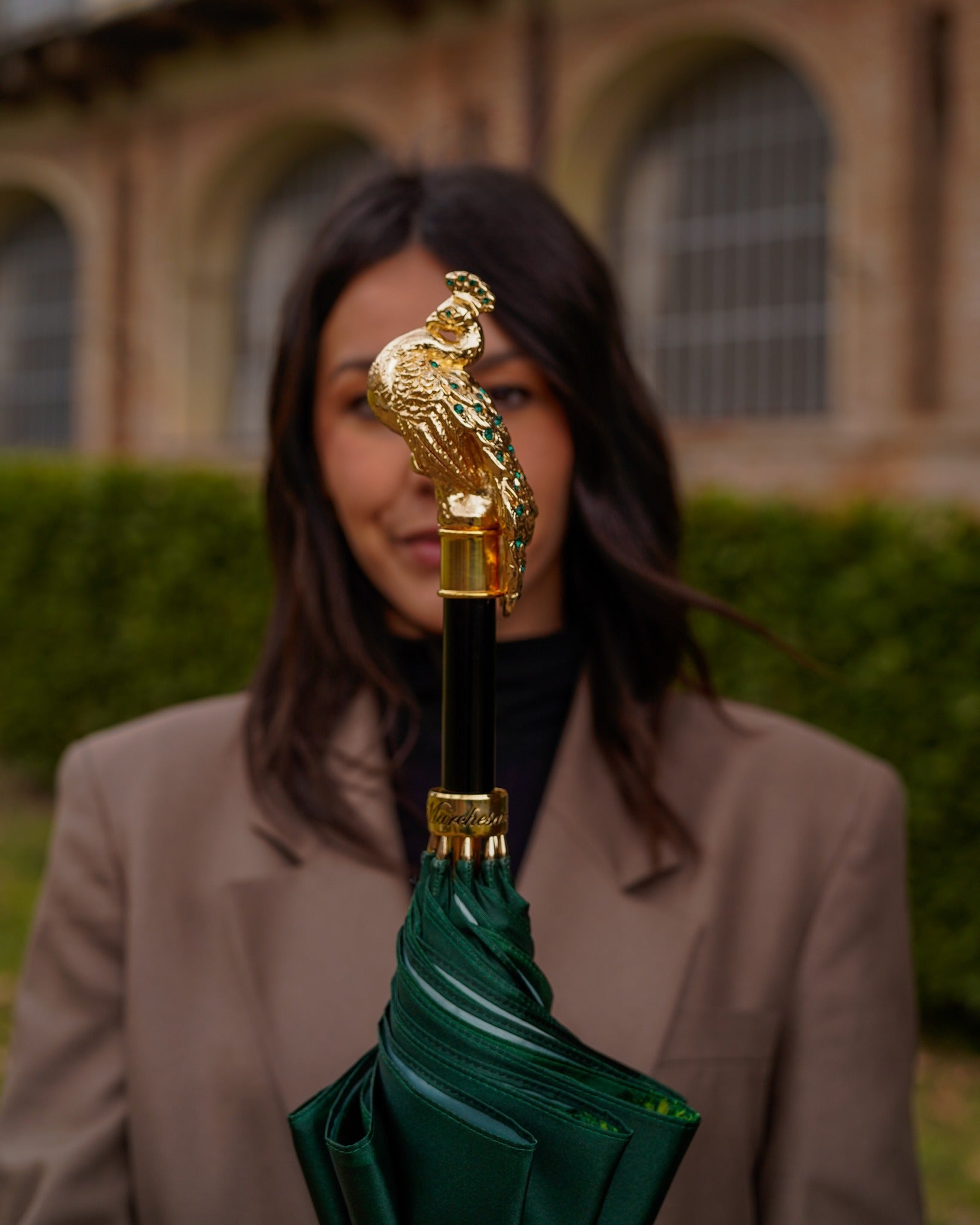 Green peacock umbrella by Ilmarchesato with handmade satin canopy, luxury rain gear for women, detailed peacock feather design.