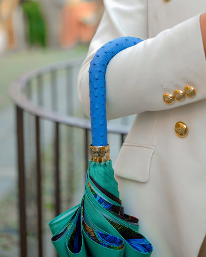 Luxury Ilmarchesato rain umbrella with peacock-inspired design and blue ostrich leather handle, stylish and durable for rainy days.
