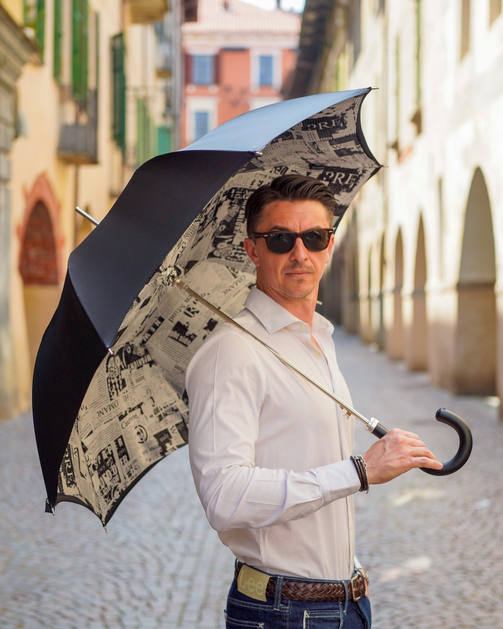 Luxury Italian rain umbrella by Ilmarchesato with wind-resistant design and leather handle, shown open against a rainy background.