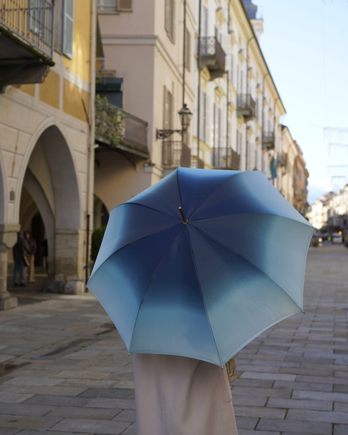 Light blue Ilmarchesato rain umbrella with gold horse handle and silk satin canopy, designed for elegant rain protection.