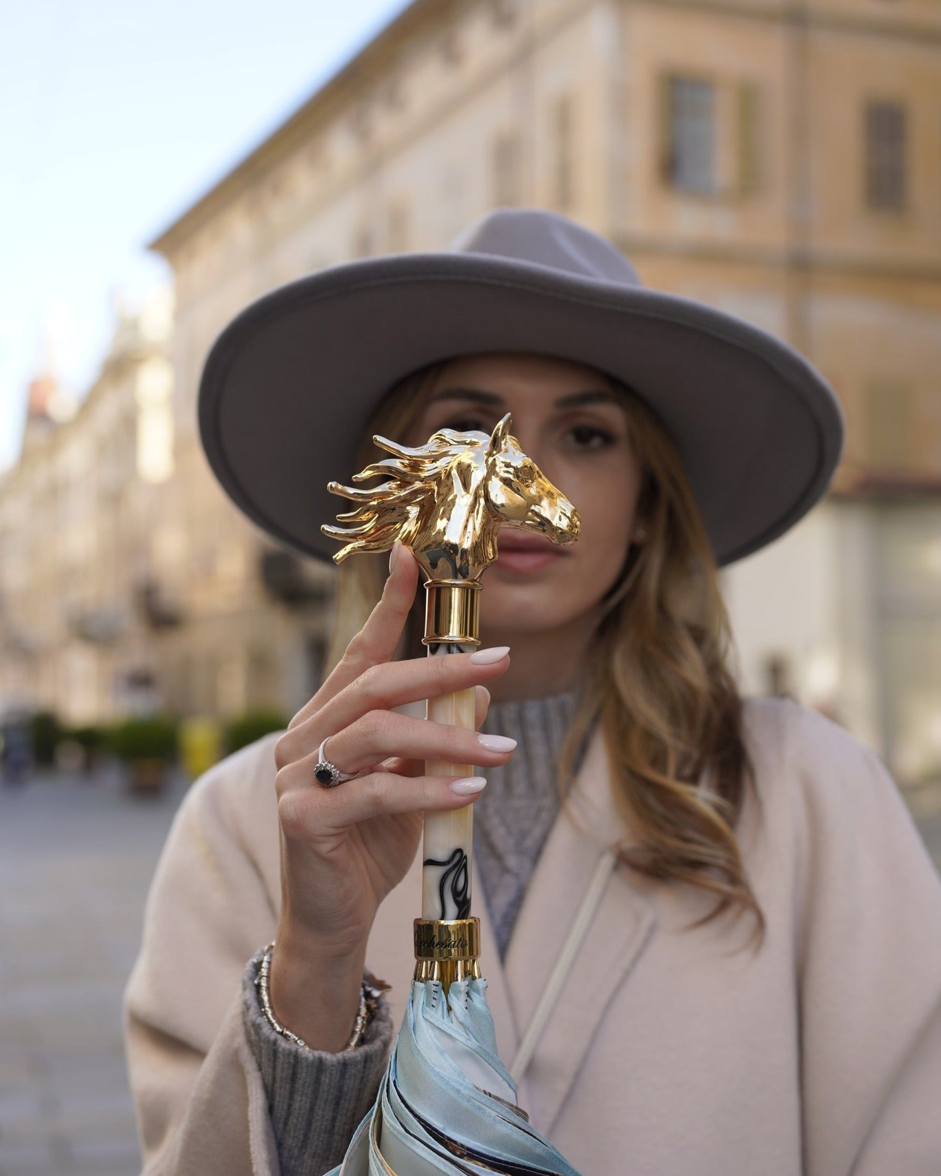 Light blue Ilmarchesato rain umbrella with gold horse handle and silk satin canopy, stylish rain protection accessory